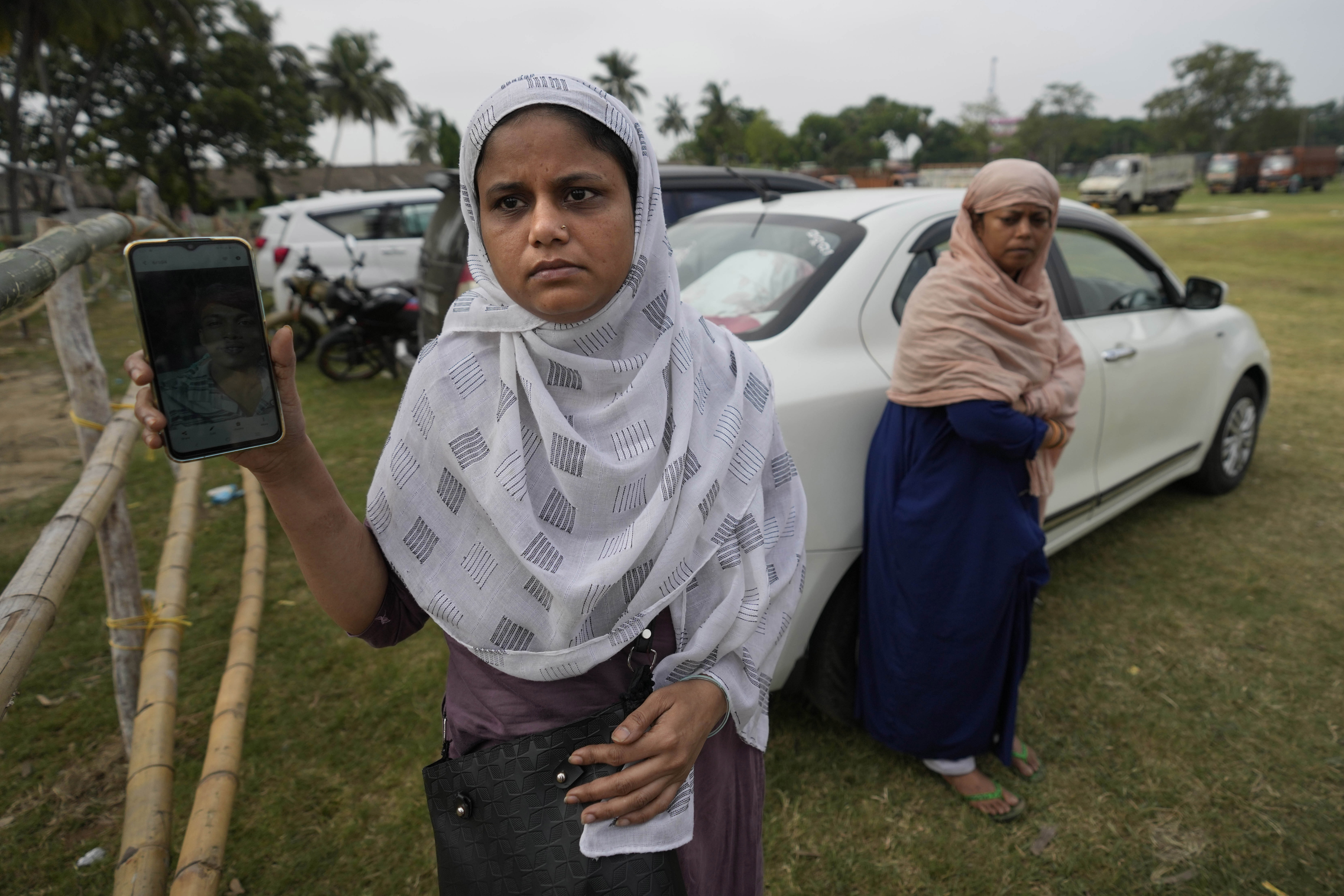 Amina, shows photo of her relative Mohammed Mzar who was traveling in the train that derailed while looking for him at the site of the accident, in Balasore district (Photo: AP)