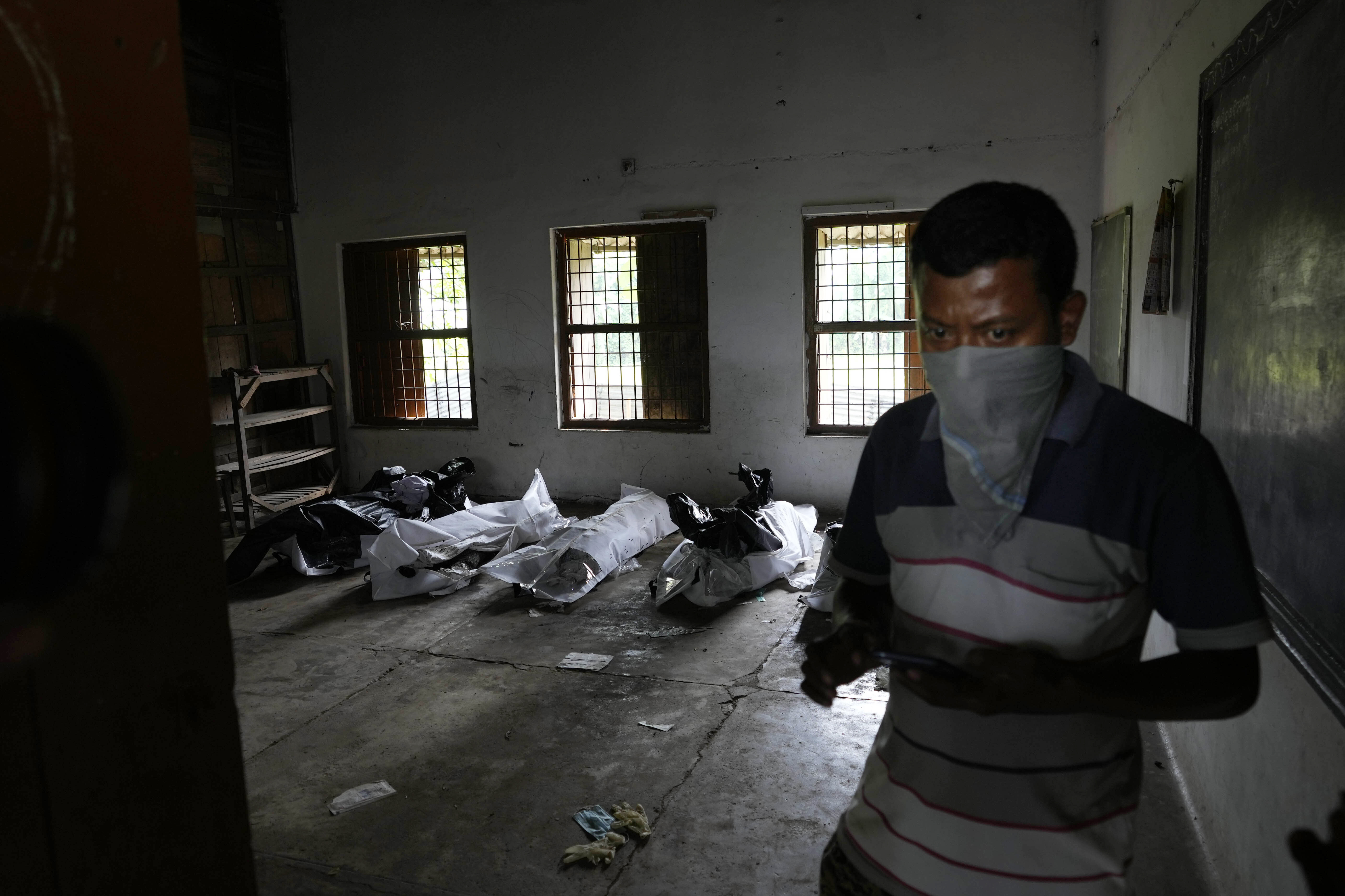 A person tries to identifies the body of his relative among the corpses kept in a school (AP photo)