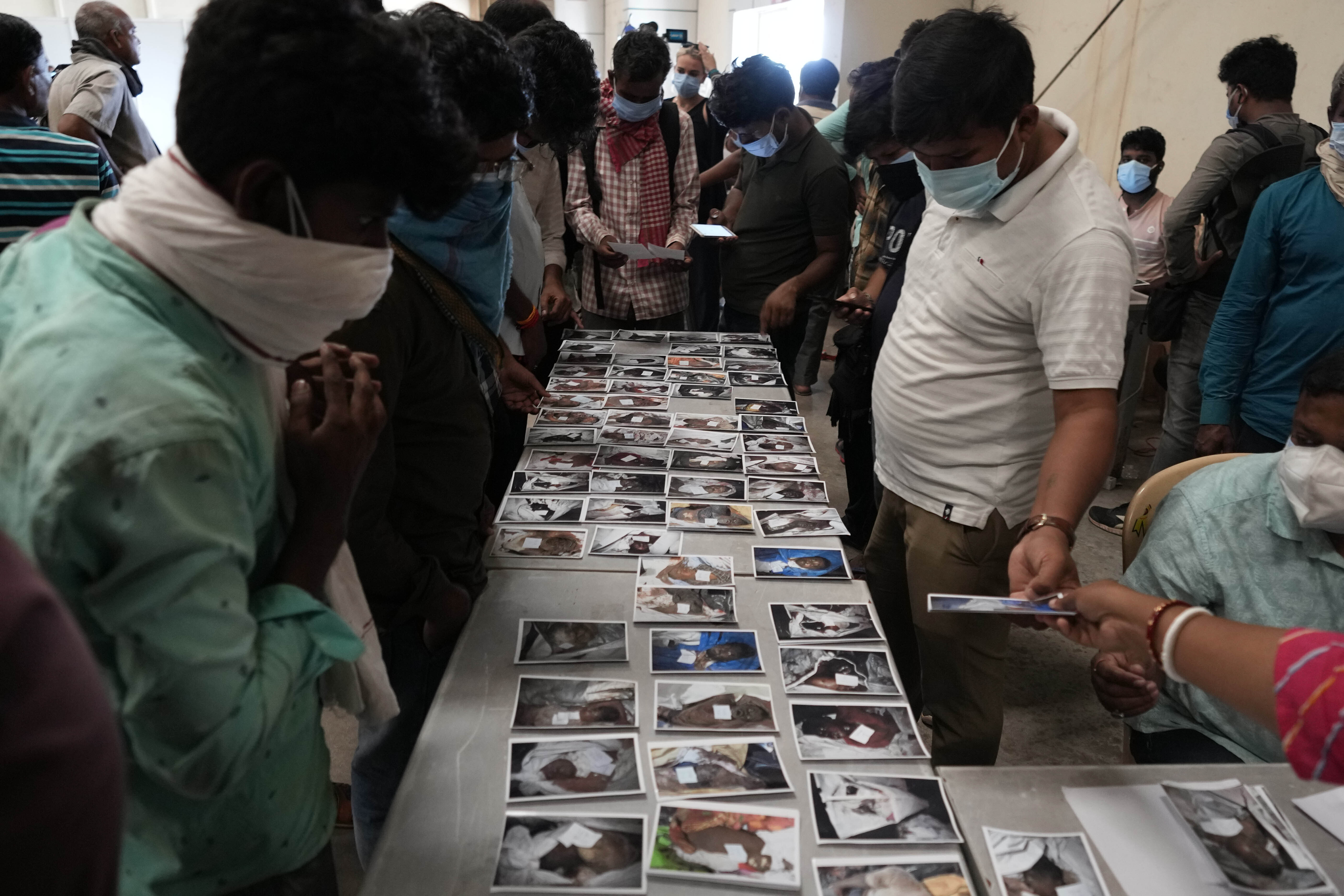 People look at the photographs of the passengers who were traveling in the trains that met with an accident in Odisha on Friday (Photo: AP)