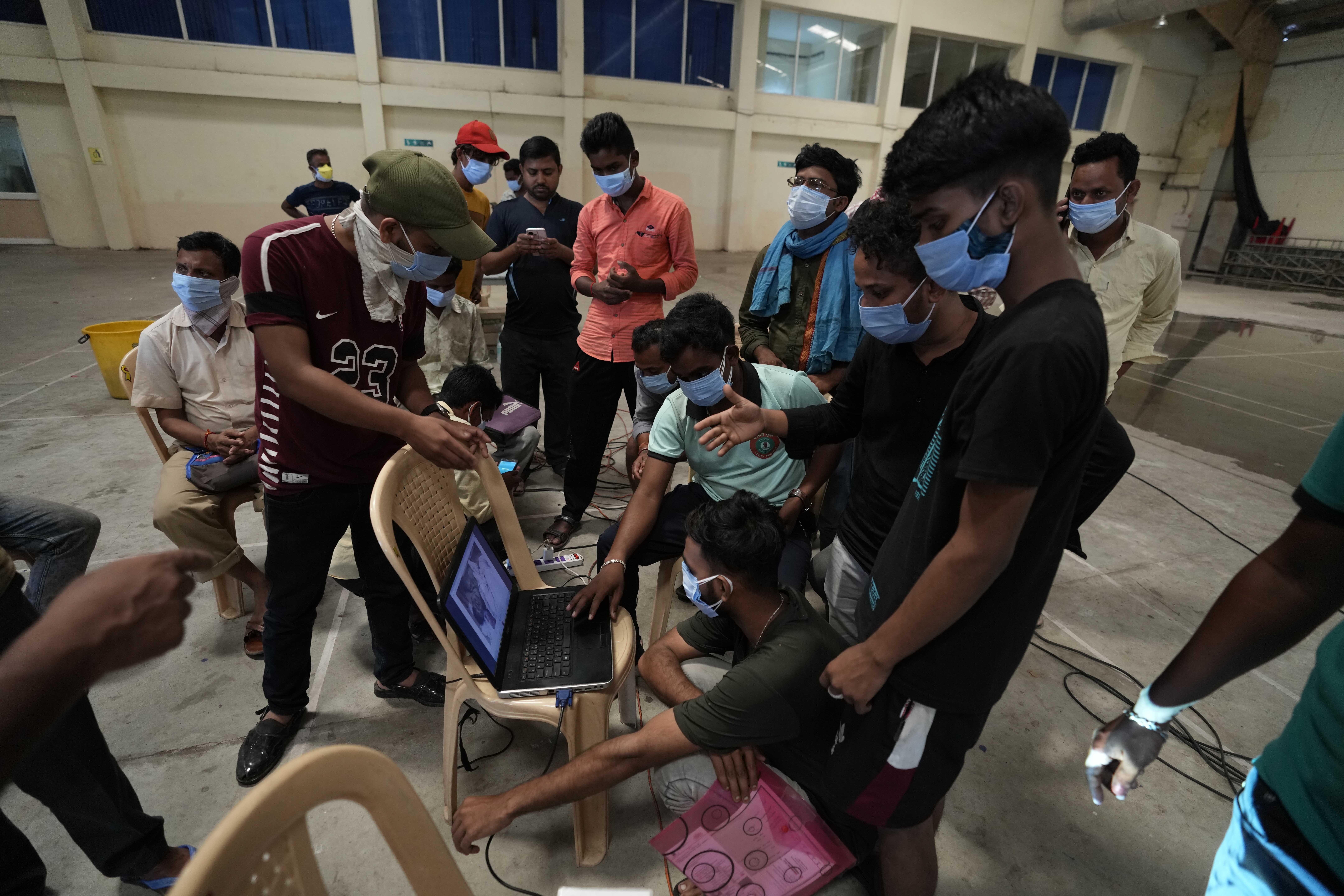 Relatives look at the photographs of unidentified bodies of passengers displayed on laptop, in Balasore district, in Orissa on Sunday, June 4, 2023. (Photo: AP)