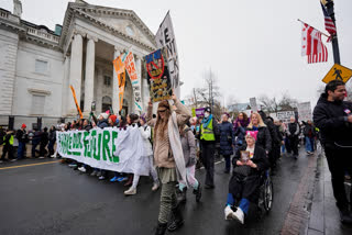 People march past the Daughters of the American Revolution National Headquarters building during the People's March, Saturday, Jan. 18, 2025, in Washington.