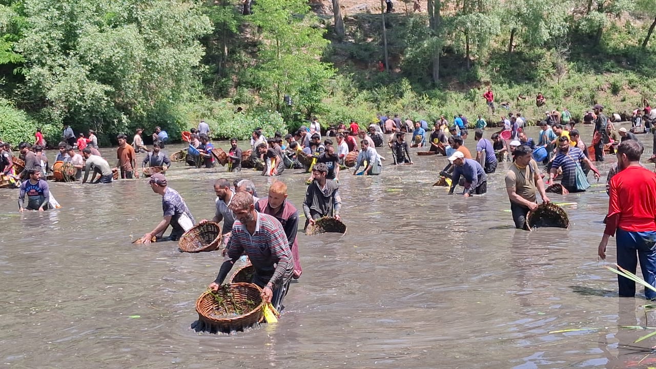Locals from Panzath and adjoining villages plunge into the spring waters with wicker baskets and bags to clean the water body from pollutants.