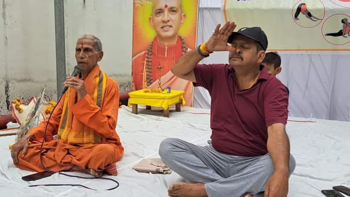 Nonagenarian Yogacharya Vishnu Arya (L) practicing yoga