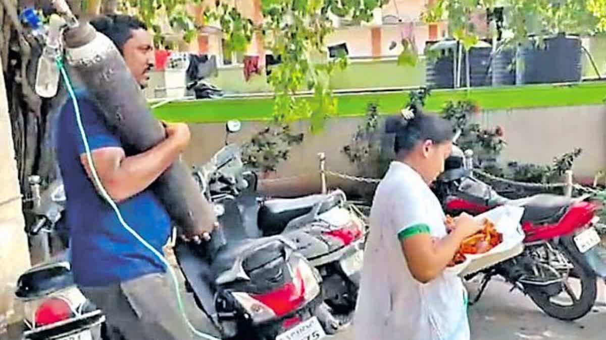 Father Carrying Oxygen Cylinder at visakhapatnam hospital