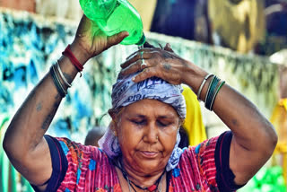 A woman pours water on her head to cool herself amid the ongoing heatwave, at the Swami Vivekananda Camp Chanakyapuri in New Delhi on Tuesday.