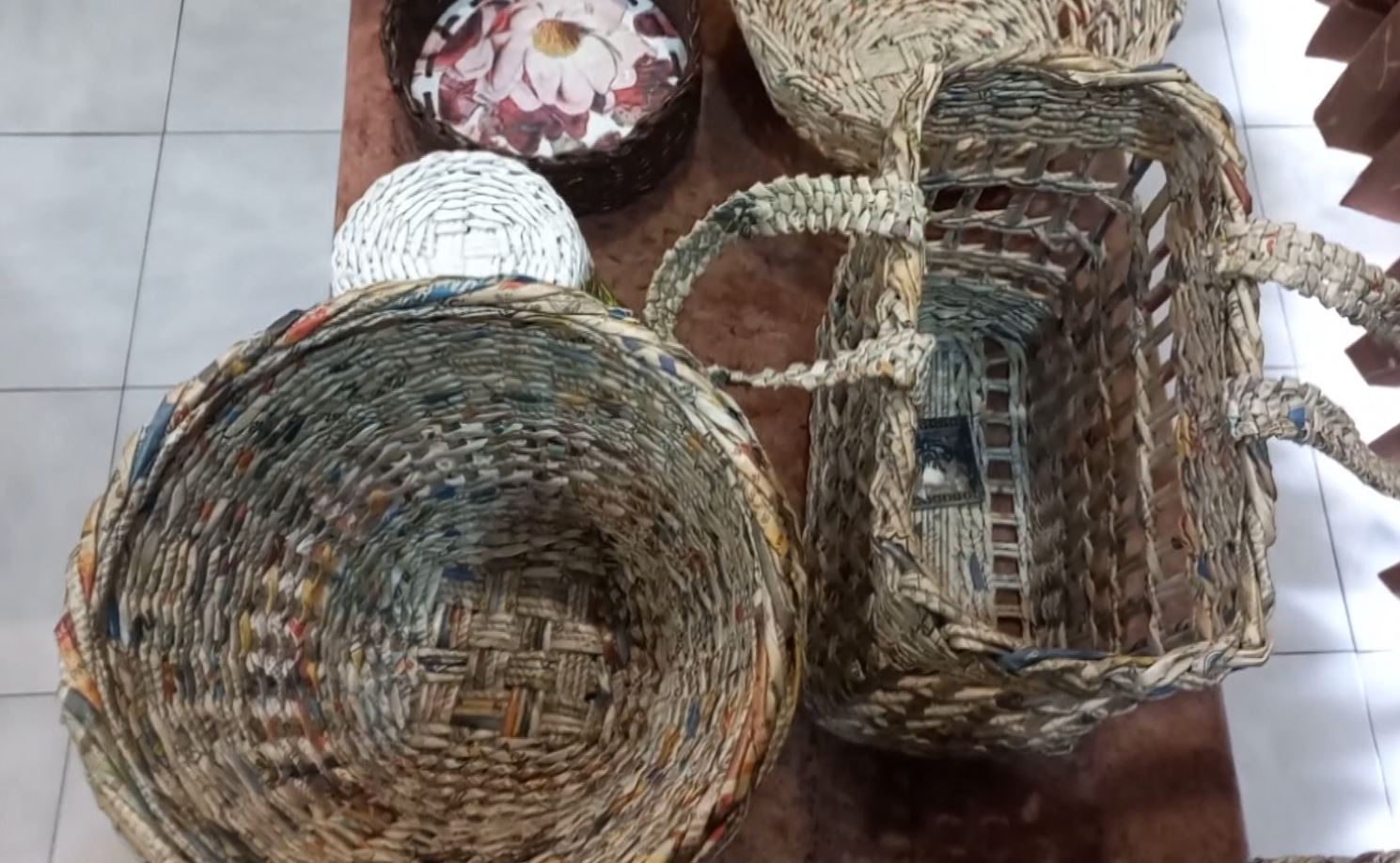 woman makes baskets from waste papers