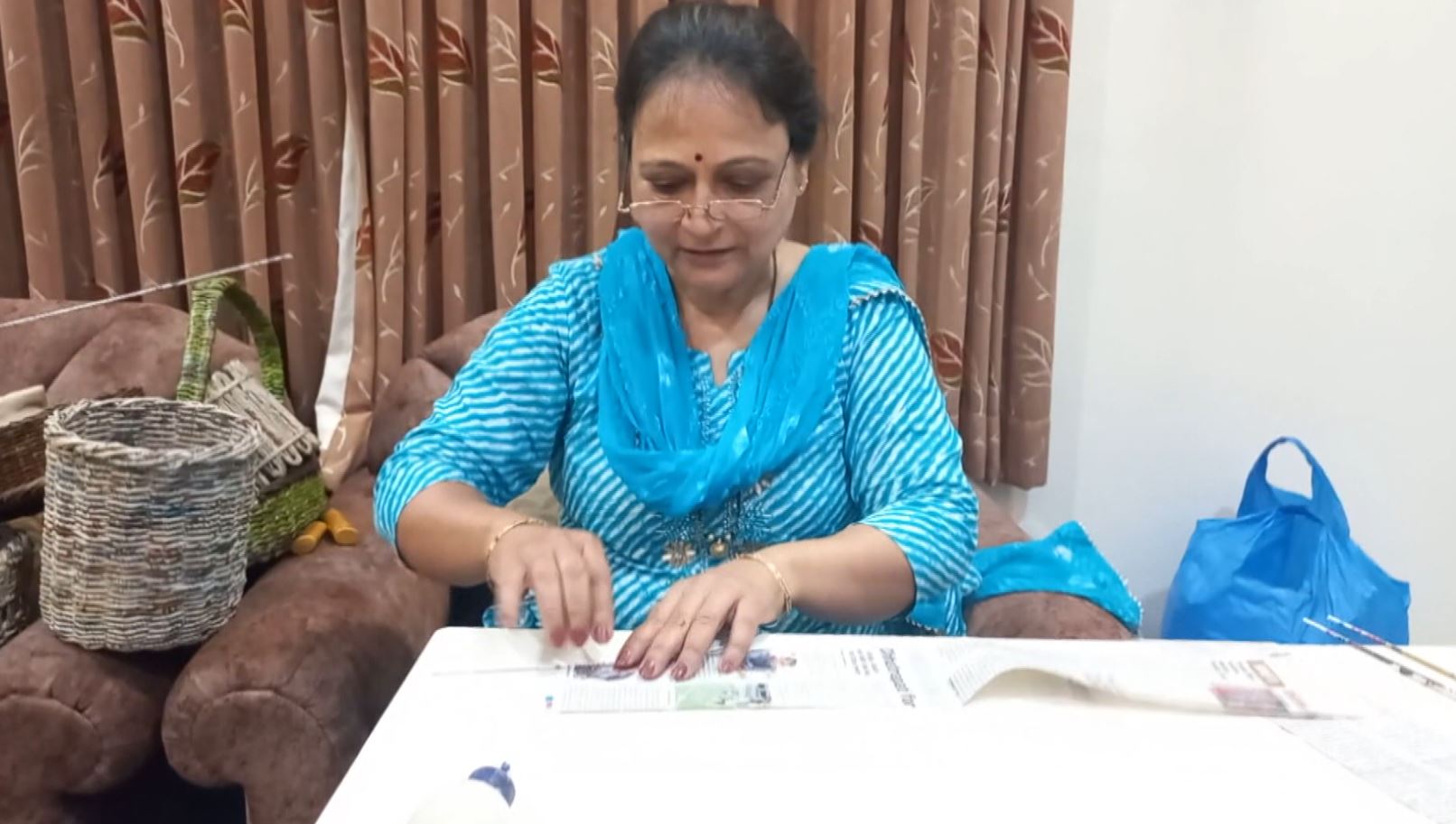 woman makes baskets from waste papers