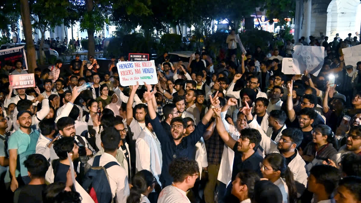 Doctors take out candle march at Connaught Place, in New Delhi on Sunday.