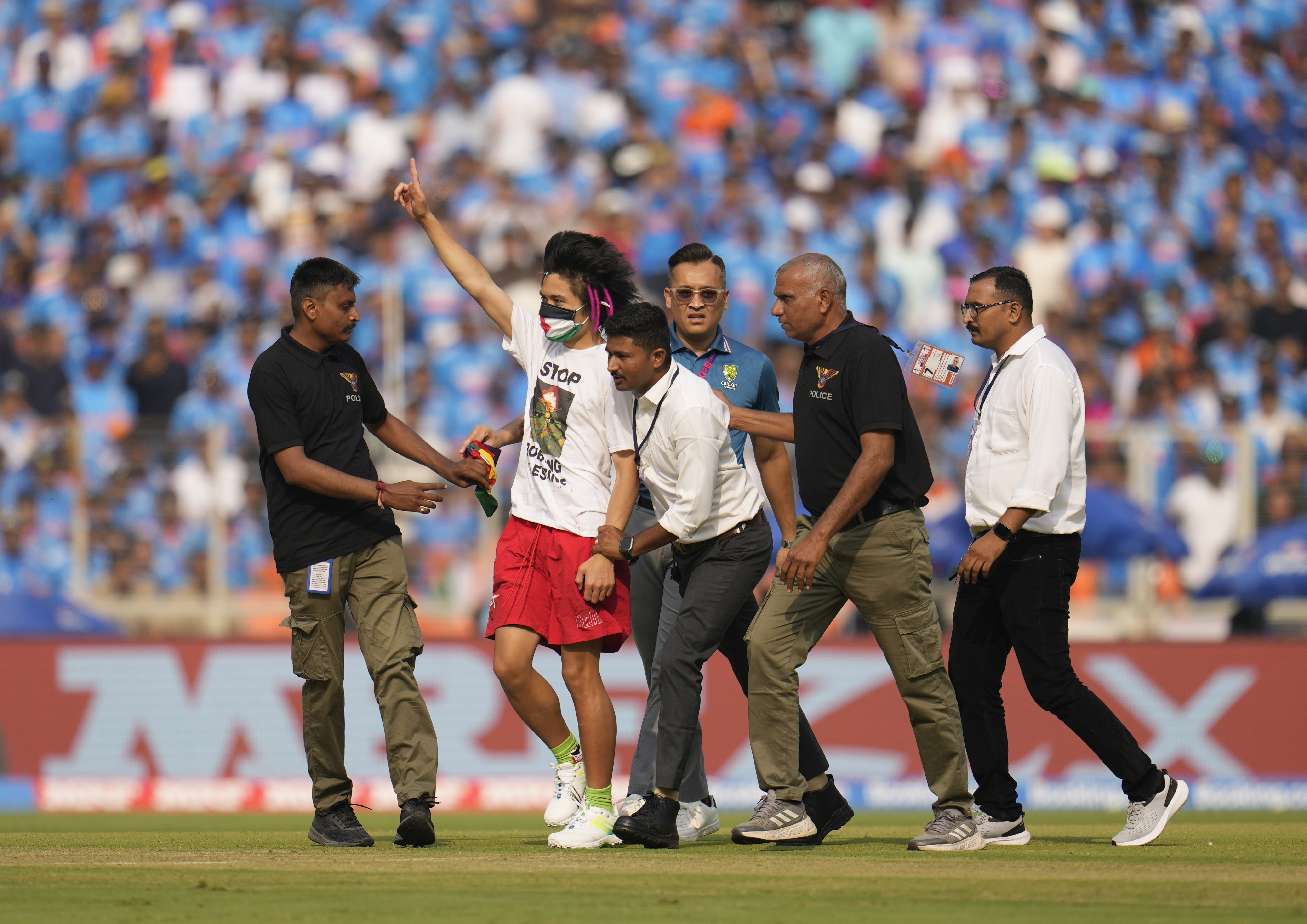 Gujarat Police are yet to identify the pitch invader who has been escorted out of the stadium, after his short cameo with Indian batting great Virat Kohli in the middle. The invader who was wearing a green, red, white and black facemask, colours that denote Palestine, managed to enter the ground and reach Kohli.