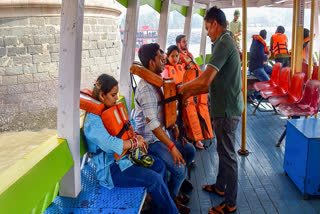 A passenger gets assisted to wear a life jacket following the distribution of life jackets to passengers after a ferry capsized off the Mumbai coast when a Navy craft crashed into it on Wednesday, in Mumbai, Thursday, Dec. 19, 2024.