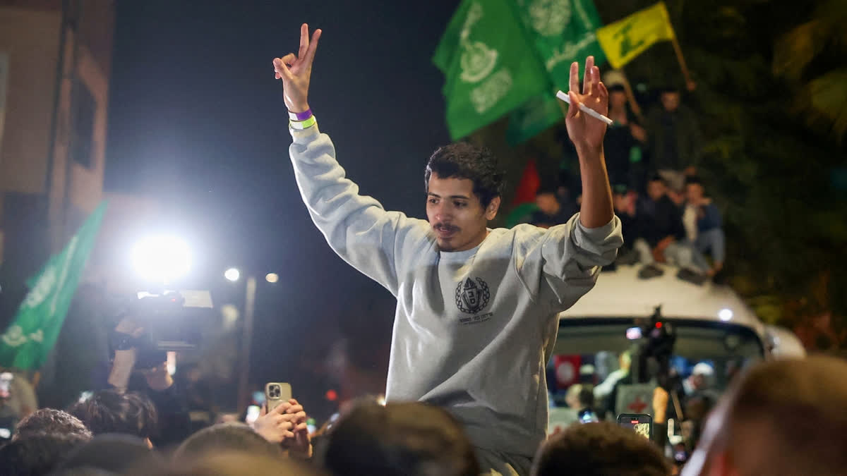 A Palestinian prisoner flashes the V-sign for victory upon his arrival in the occupied West Bank town of Beitunia, on the outskirts of Ramallah, following his release from an Israeli jail in the early hours of January 20, 2025.