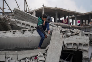 A child sits on the rubble of a house destroyed by the Israeli army's air and ground offensive against Hamas in Jabaliya, northern Gaza Strip on Wednesday, Feb. 19, 2025.