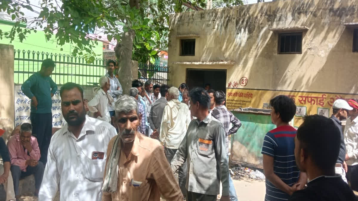 People present outside the post mortem room of the hospital after the death in harsh firing in Dholpur.