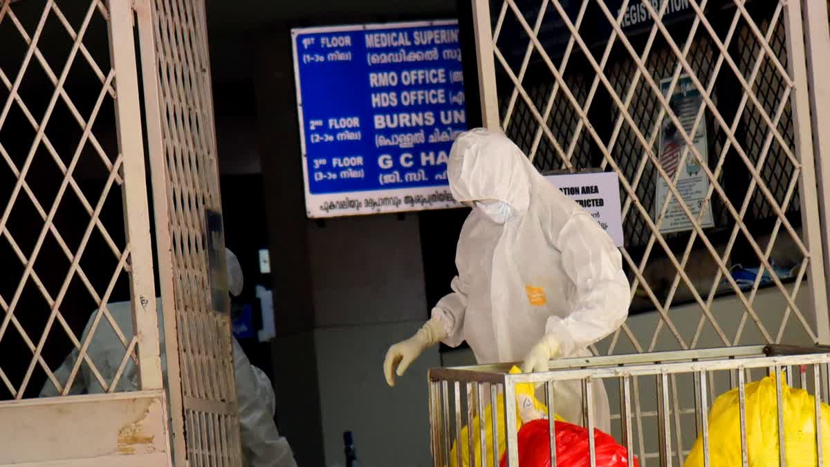 Hospital staff collects waste outside an isolation ward of Ernakulam Medical College after rise in the number of cases of Nipah virus in Kochi