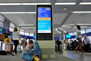 An information display shows a flight delay at Chicago International Airport in Chicago, Friday, July 19, 2024, after software issues delayed and canceled flights globally.
