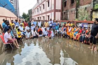 MLA protest by sitting in dirty water on road in Dhanbad