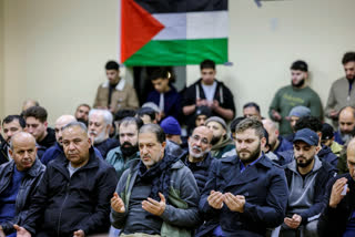 Men hold up their hands during a prayer at the reception for late Palestinian-American teenager Tawfiq Ajaq, 17, who was killed Friday by Israeli fire in the occupied West Bank, at Masjid Omar mosque in Harvey, La., Saturday, Jan. 20, 2024. (Sophia Germer/The Times-Picayune/The New Orleans Advocate via AP)