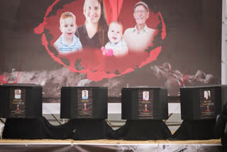 militant stands next to the coffins containing the bodies of hostages, from right to left, Shiri Bibas, her two children, Ariel and Kfir and Oded Lifshitz, who was 83 when he was abducted before their are handed over to the Red Cross in Khan Younis, southern Gaza Strip, Thursday, Feb. 20, 2025.