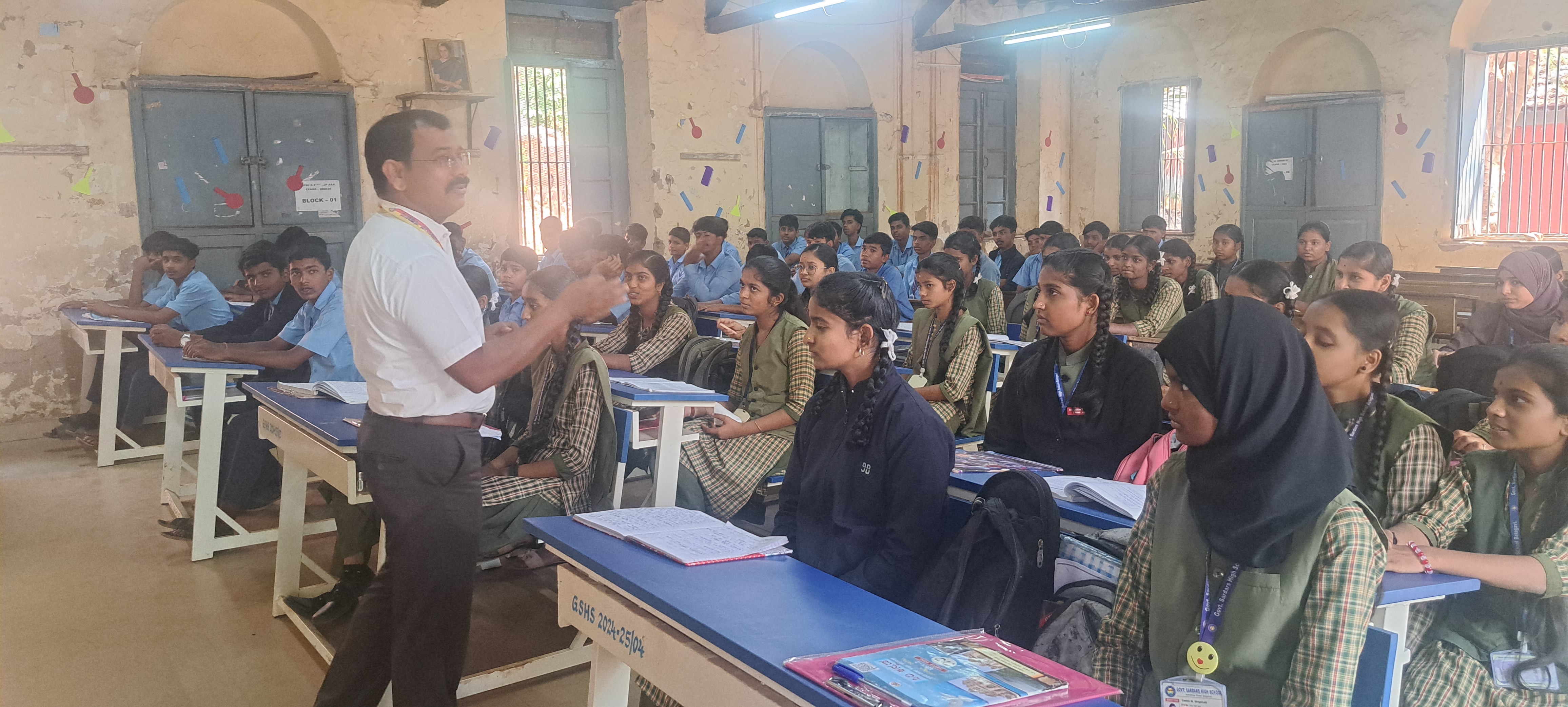 teacher teaching poet introduction to students through film songs in belagavi