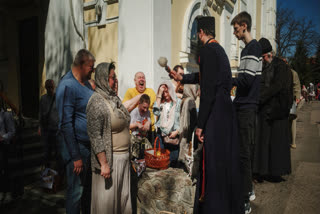 A priest blesses Easter baskets during the celebration of Orthodox Easter at Cross Lower Church of the Ukrainian Orthodox Church in Kharkiv, Ukraine, on Sunday, April 20, 2025.