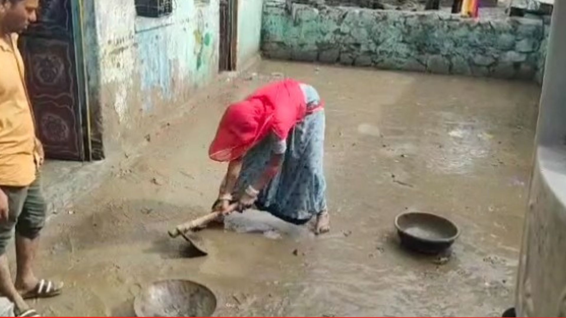 બિપરજોય વરસાદ પછી ડૂબી ગયેલા ઘરોમાંથી કાટમાળ હટાવતી મહિલા