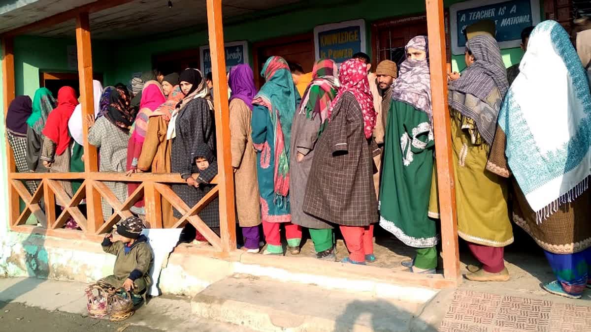 Women voters queue up outside a polling booth in Kashmir