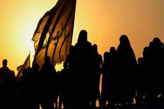 The sun sets as Shiite pilgrims march on their way to Karbala for Arbaeen in Babil, Iraq, Monday, Aug. 19, 2024.