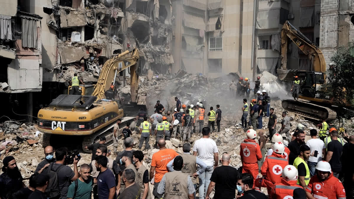 Emergency workers use excavators to clear the rubble at the site of Friday's Israeli strike in Beirut's southern suburbs, Saturday, Sept. 21, 2024.