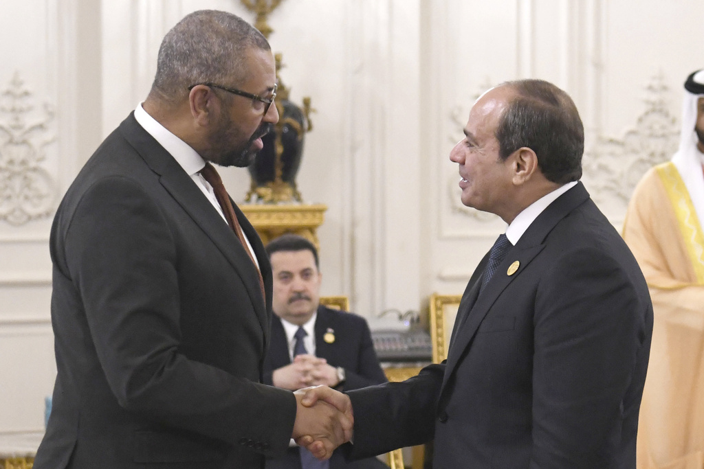In this photo provided by Egypt's presidency media office, Egyptian President Abdel Fattah el-Sissi, right, greets British Secretary of State for Foreign Affairs James Cleverly, during the International peace summit at the New Administrative Capital, just outside Cairo, Egypt, Saturday, Oct. 21, 2023. (Egyptian Presidency Media Office via AP)