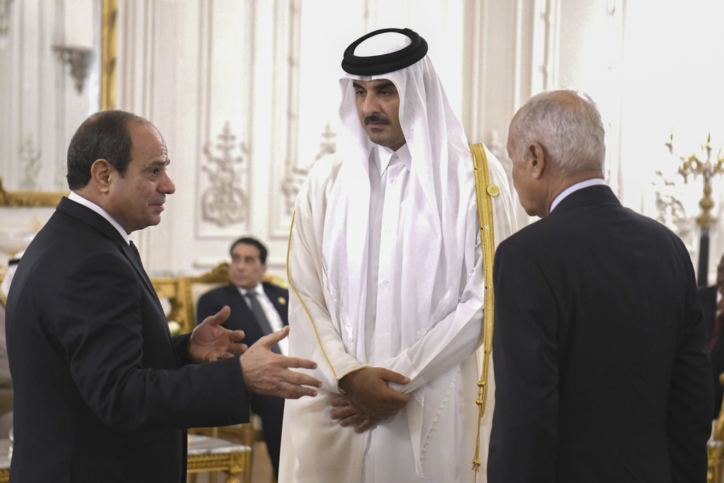 In this photo provided by Egypt's presidency media office, Egyptian President Abdel Fattah el-Sissi, left, and Secretary-General Ahmed Aboul Gheit, talk to Qatari Emir Sheikh Tamim bin Hamad Al Thani, during the International peace summit at the New Administrative Capital, just outside Cairo, Egypt, Saturday, Oct. 21, 2023. (Egyptian Presidency Media Office via AP)