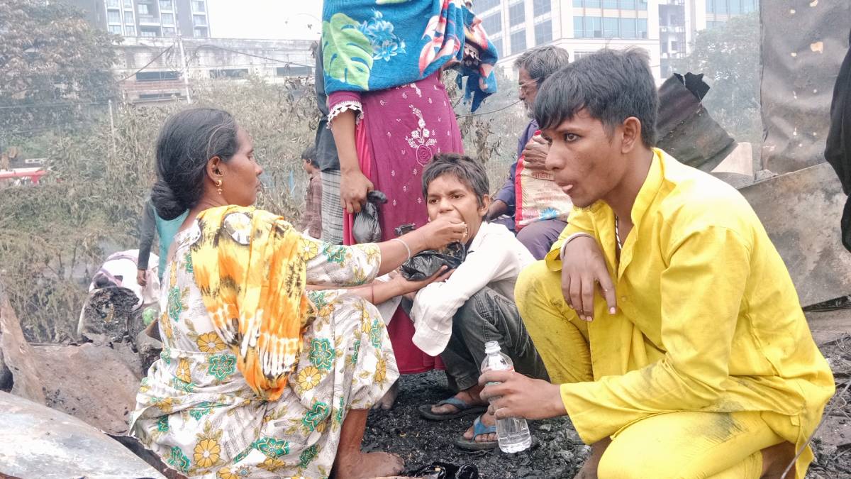 A mother feeds her son on their former house, now turned to ashes