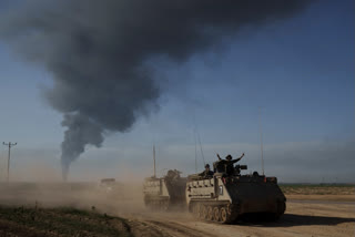 Israeli soldiers move on armored personnel carriers (APC) near the Israeli-Gaza border as smoke rises to the sky in the Gaza Strip, seen from southern Israel, Sunday, Jan. 21, 2024. (AP Photo/Leo Correa)