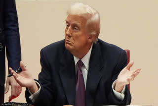 President Donald Trump gestures as he signs executive orders at an indoor Presidential Inauguration parade event