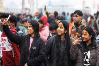 Devotees pose for a selfie at Triveni Sangam on the occasion of ‘Paush Purnima’ at the Maha Kumbh