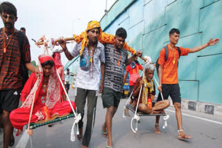 Four brothers from Bhiwani, carrying their parents on their shoulders leave after taking a dip in Nilkanth, Rishikesh and Haridwar during the Kanwar Yatra, in Haridwar on Friday.