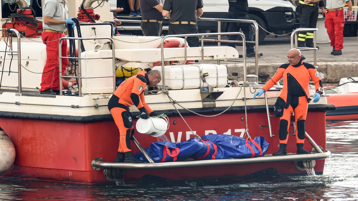 Italian firefighter divers bring ashore in a plastic bag the body of one of the victims of a shipwreck, in Porticello, Sicily, southern Italy on Thursday.