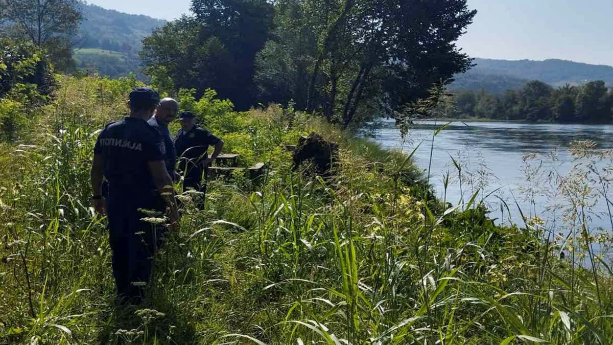 Serbian Police officers search a bank of the Drina River near the town of Ljubovija in Serbia on Thursday