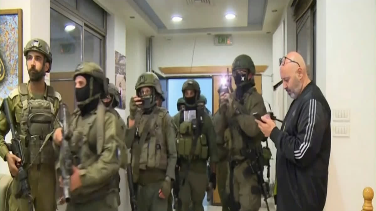 This image made from video provided by Al Jazeera English shows Israeli troops raiding their bureau in Ramallah, West Bank