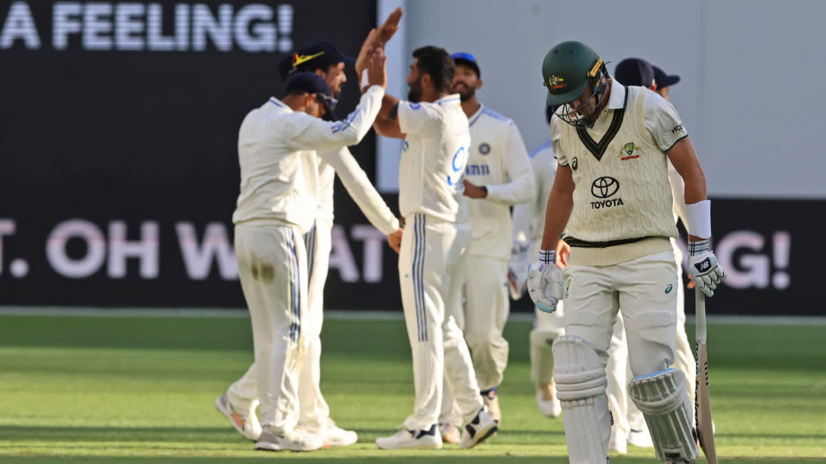 India's players celebrate the wicket of Australia's captain Pat Cummins, right, foreground, as he leaves the field after losing his wicket