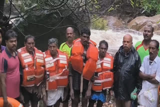 வெள்ளத்தில் இருந்து மீட்கப்பட்ட மலை கிராம மக்களுடன்  தீயணைப்பு துறையினர்