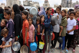 Palestinians distribute bundles of bread to displaced people after aid reaches Gaza, the first such delivery since Israel imposed a total blockade on March 2.