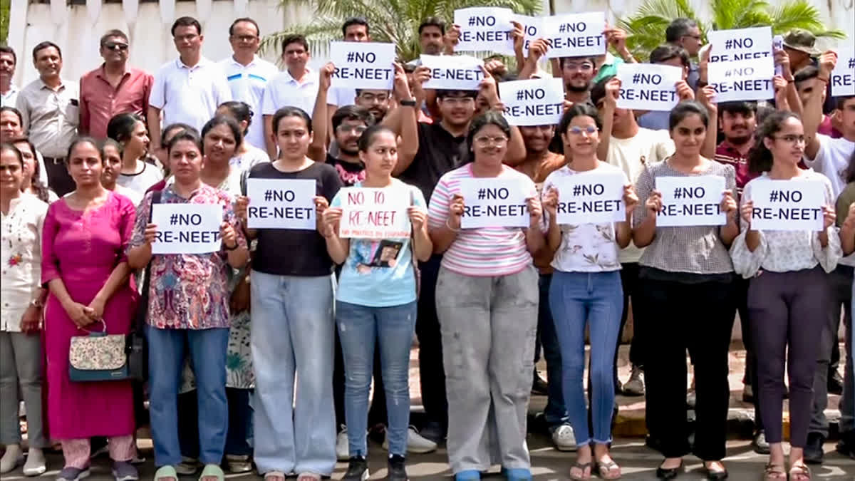 Students hold placards as they stage a protest against the re-examination of the NEET-UG exams, in Rajkot on Sunday.