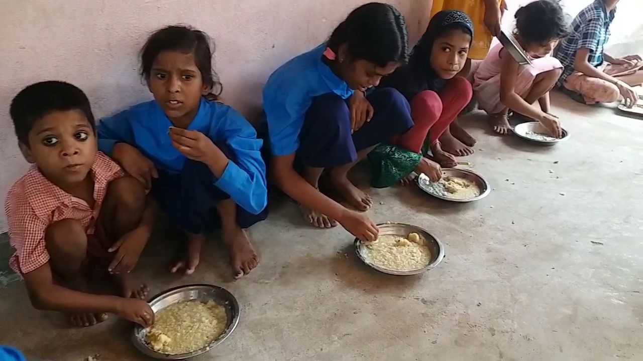मध्याह्न भोजन खाते बच्चे.