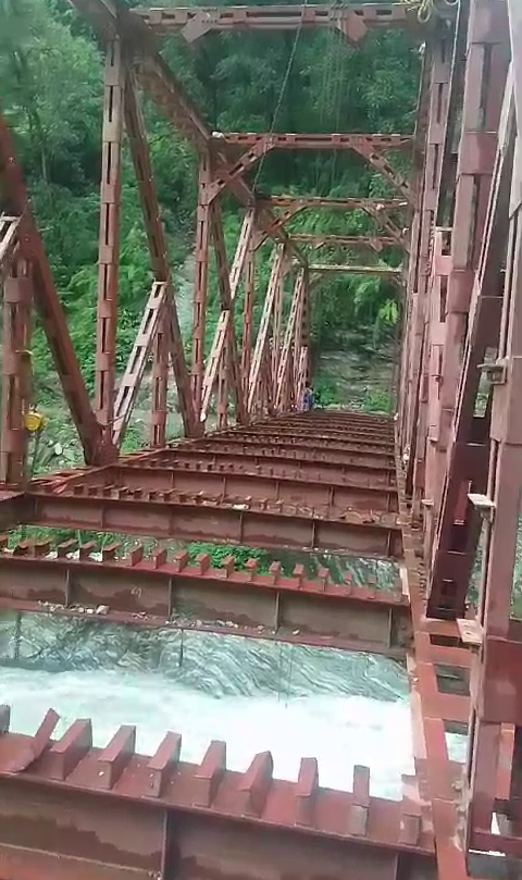 People Crossing Under Construction Bridge