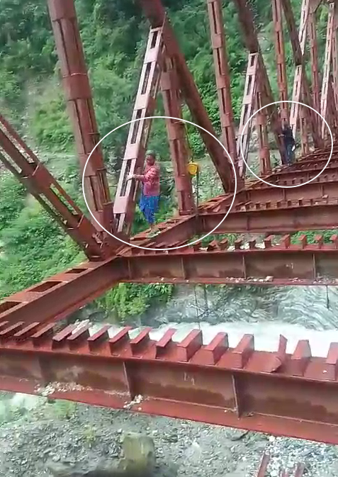 People Crossing Under Construction Bridge