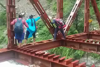 People Crossing Under Construction Bridge