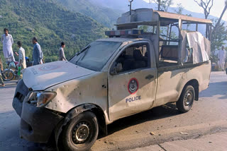 People gather near a damaged police vehicle which was escorting a convoy of foreign diplomats, at the site of a fatal bomb explosion on a road near Malam Jabba, a tourist area in Pakistan's Khyber Pakhtunkhwa province, Sunday, Sept. 22, 2024