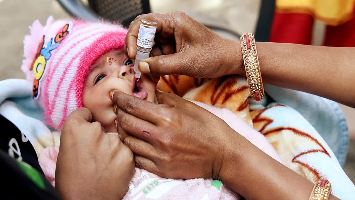 A child receives polio drops during the National Polio Immunization Drive