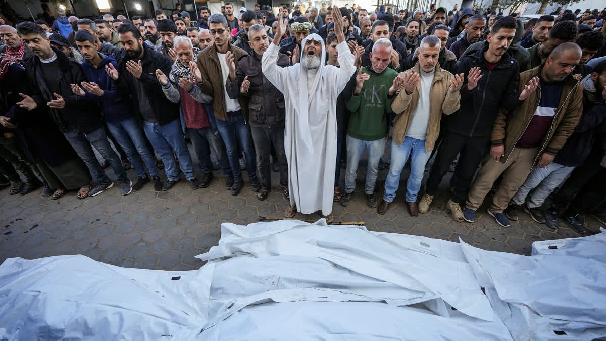 Palestinians pray over the bodies of the victims of an Israeli strike on a home late Saturday before the funeral outside the Al-Aqsa Martyrs Hospital in Deir al-Balah Sunday, Dec. 22, 2024.