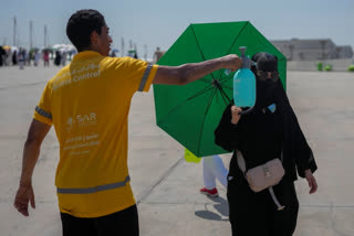 A pilgrim receives cold water spray after she cast stones at a pillar in the symbolic stoning of the devil, the last rite of the annual Hajj pilgrimage in Mina, near the holy city of Mecca, Saudi Arabia, on Tuesday, June 18, 2024.